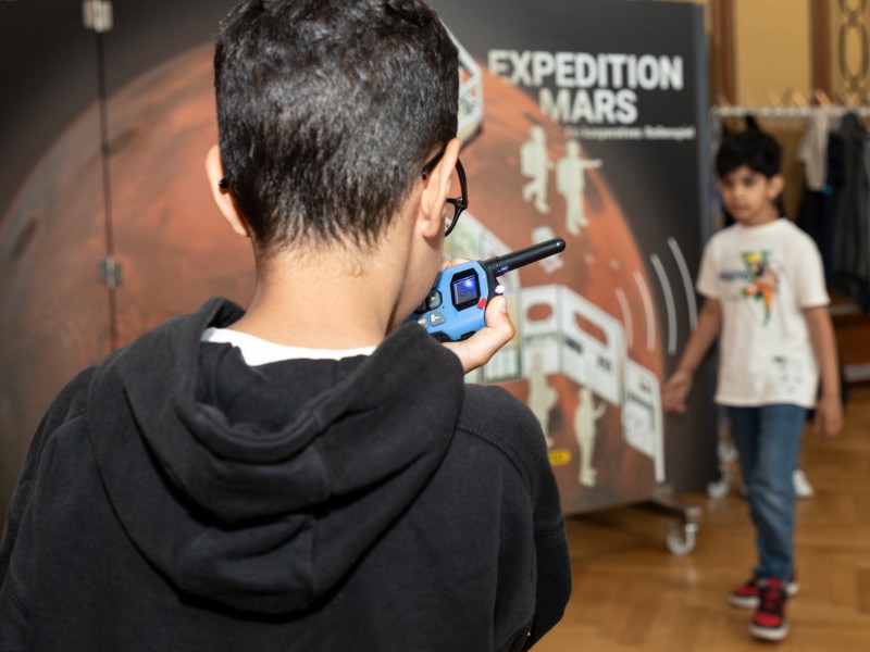 Kind spricht in ein Walki Talki: Mission Control an Mars … can you hear me?