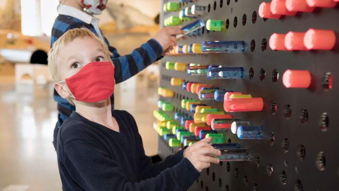 Kinder drehen an bunten Knöpfen im Erlebnisbereich miniXplore Hands-On: Technik mit allen Sinnen begreifen