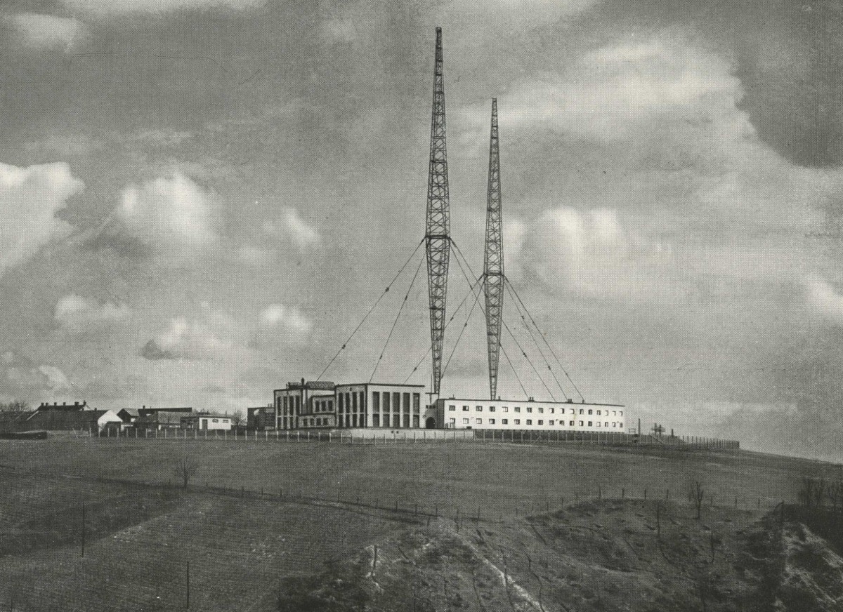 Sender Bisamberg, 1934: Historisches Schwarzweißfoto der Sendeanlage Bisamberg mit zwei hohen Antennen und einem Gebäudekomplex